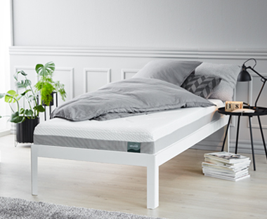 Penový matrac na posteli a sivé obliečky