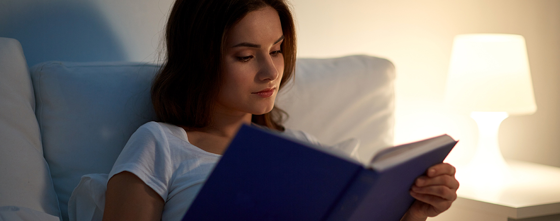 Žena si číta knihu v posteli