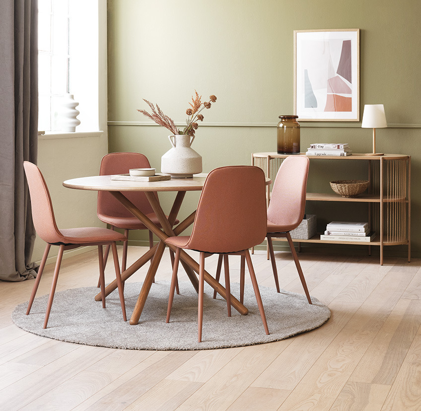 Coral dining chairs around round dining table in living room  
