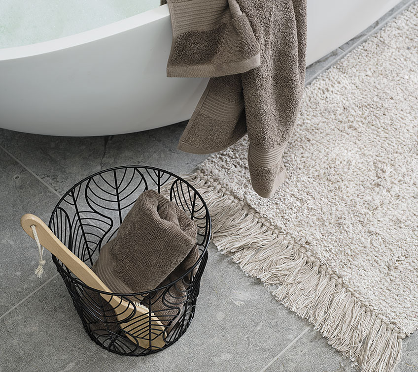 Storage basket with towel and bath brush and bathmat