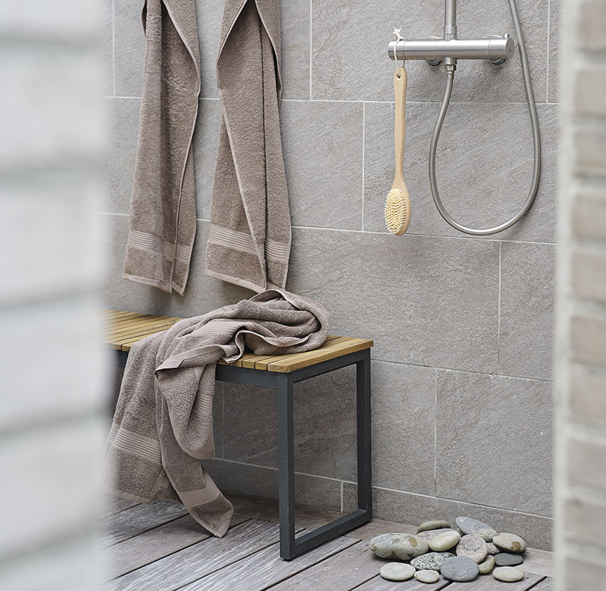 Bathroom with bench, towels and bath brush 