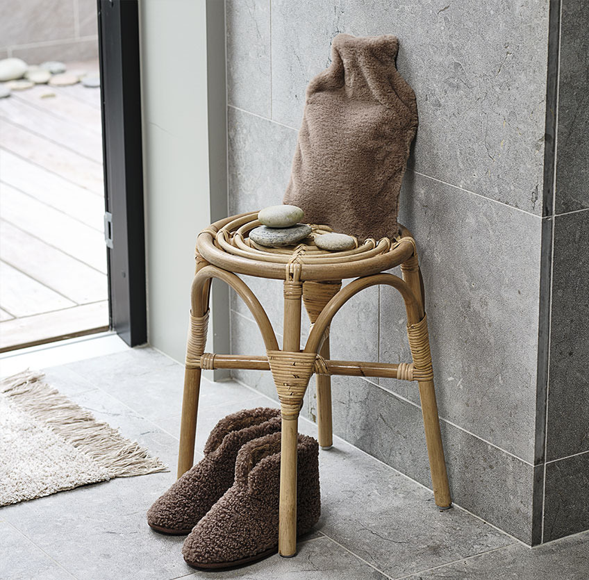 Slippers under a stool with hot water bottle on top