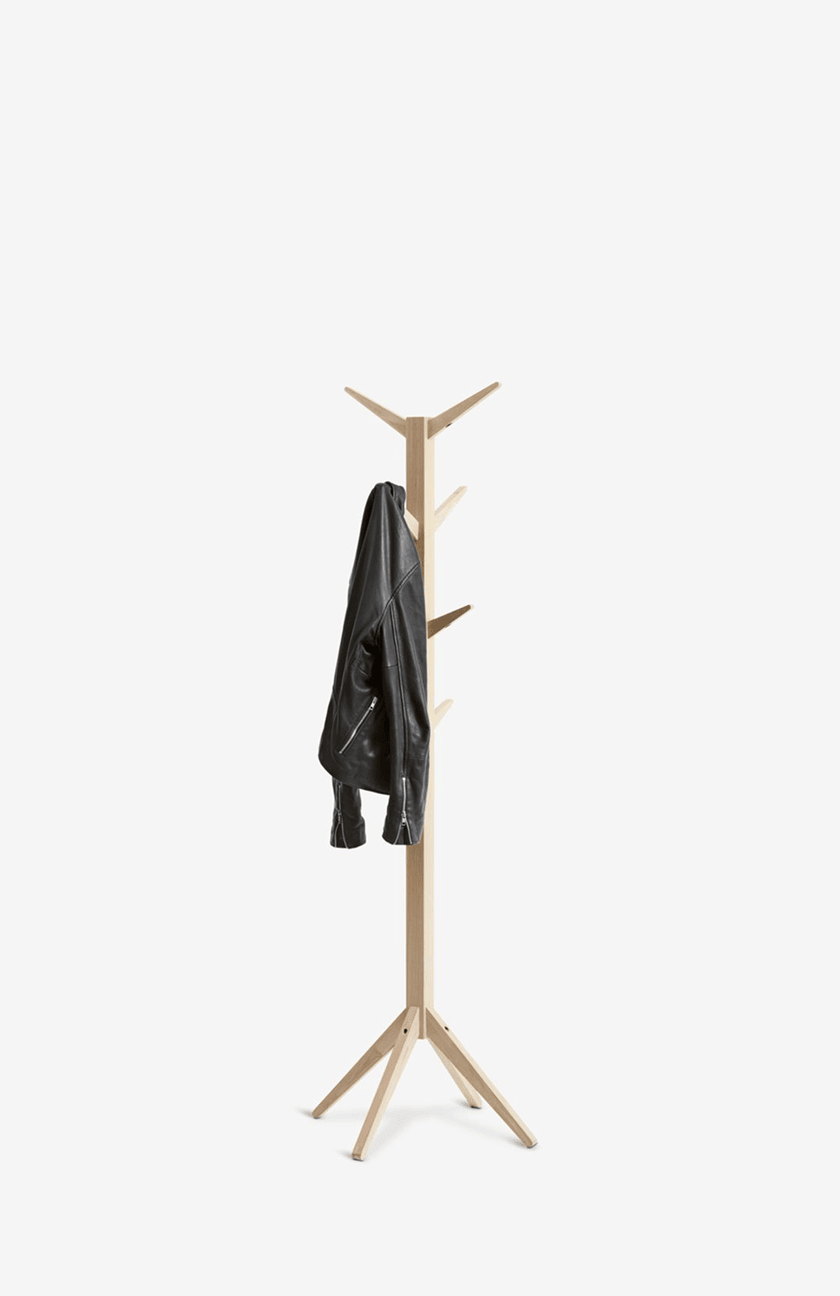 Coat stands Natural wood coat stand with angled pegs, holding a black leather jacket.