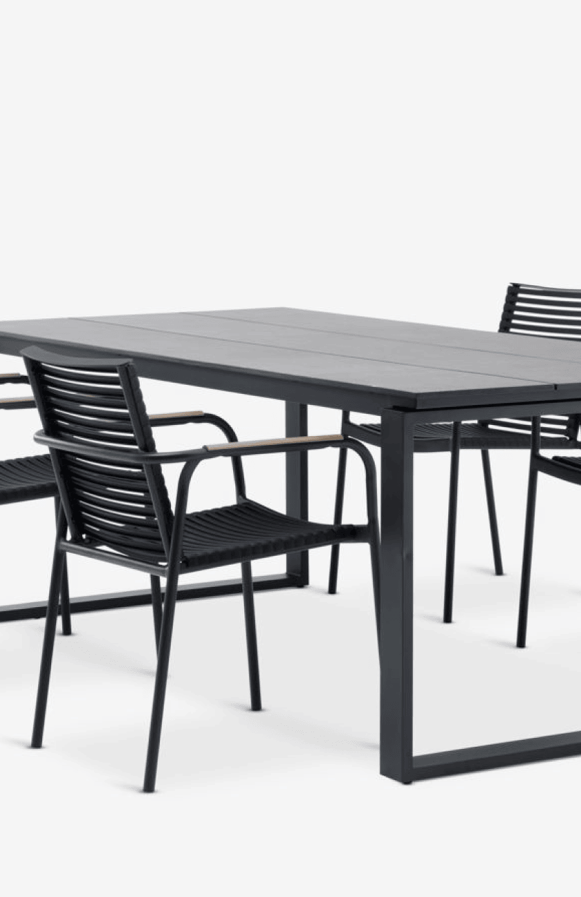 Composite sets Four black woven wicker dining chairs around a black composite-top table with a dark metal frame, shown against a plain white background.