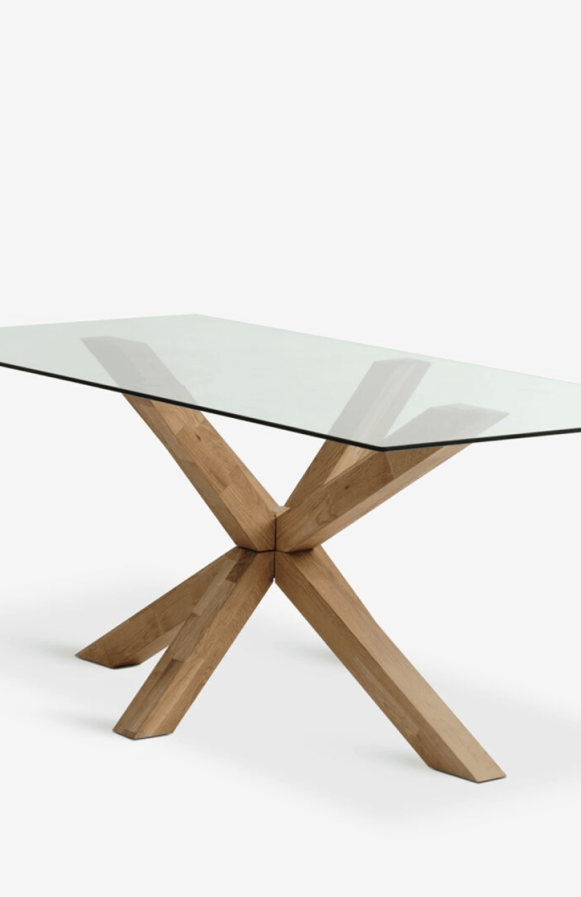Rectangular glass-top dining table with a crossed oak leg base, shown against a plain white background.