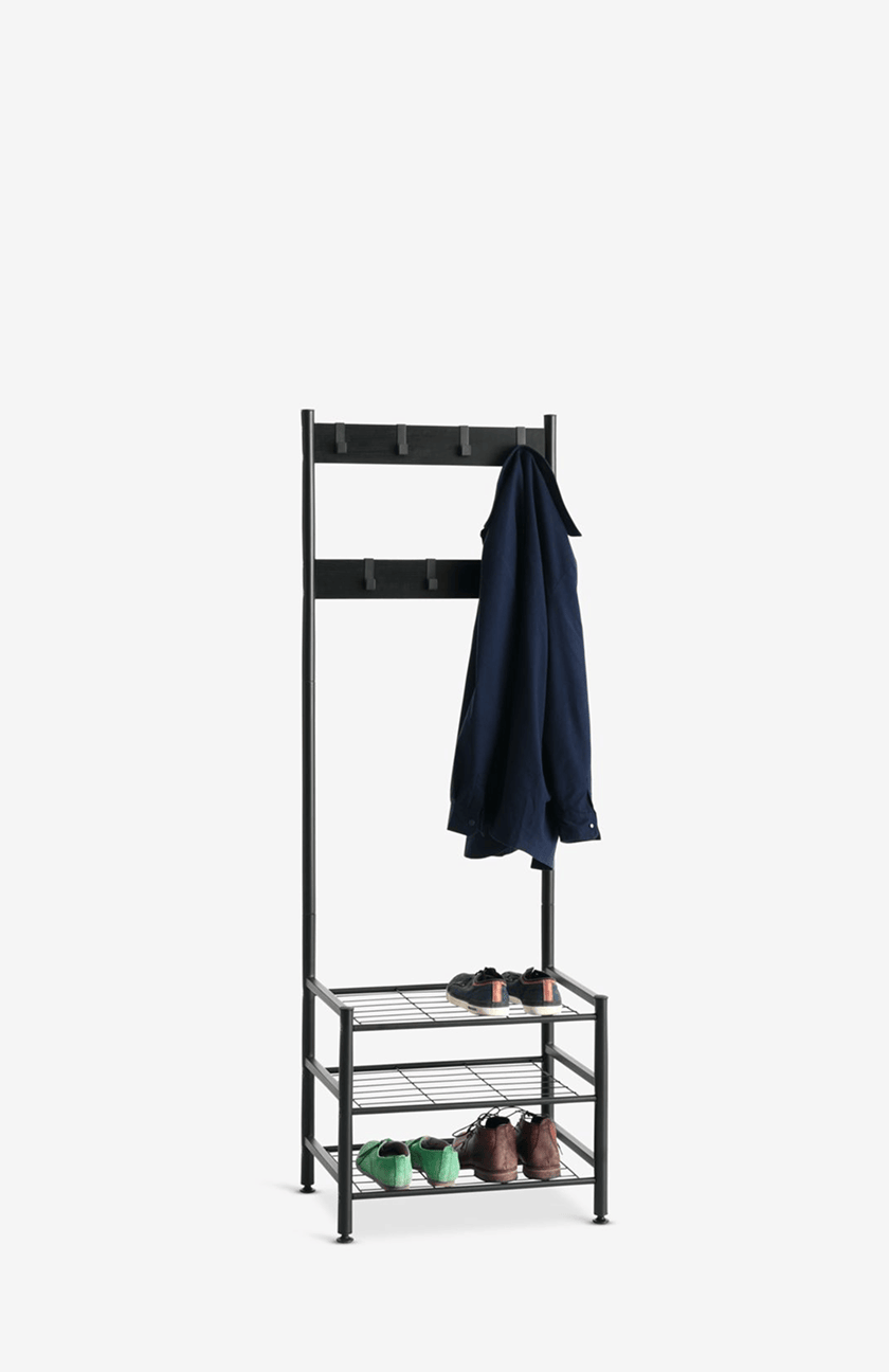 Hallway units Black metal hall tree with double coat hooks and a three-tier shoe shelf, holding a navy shirt and pairs of shoes.