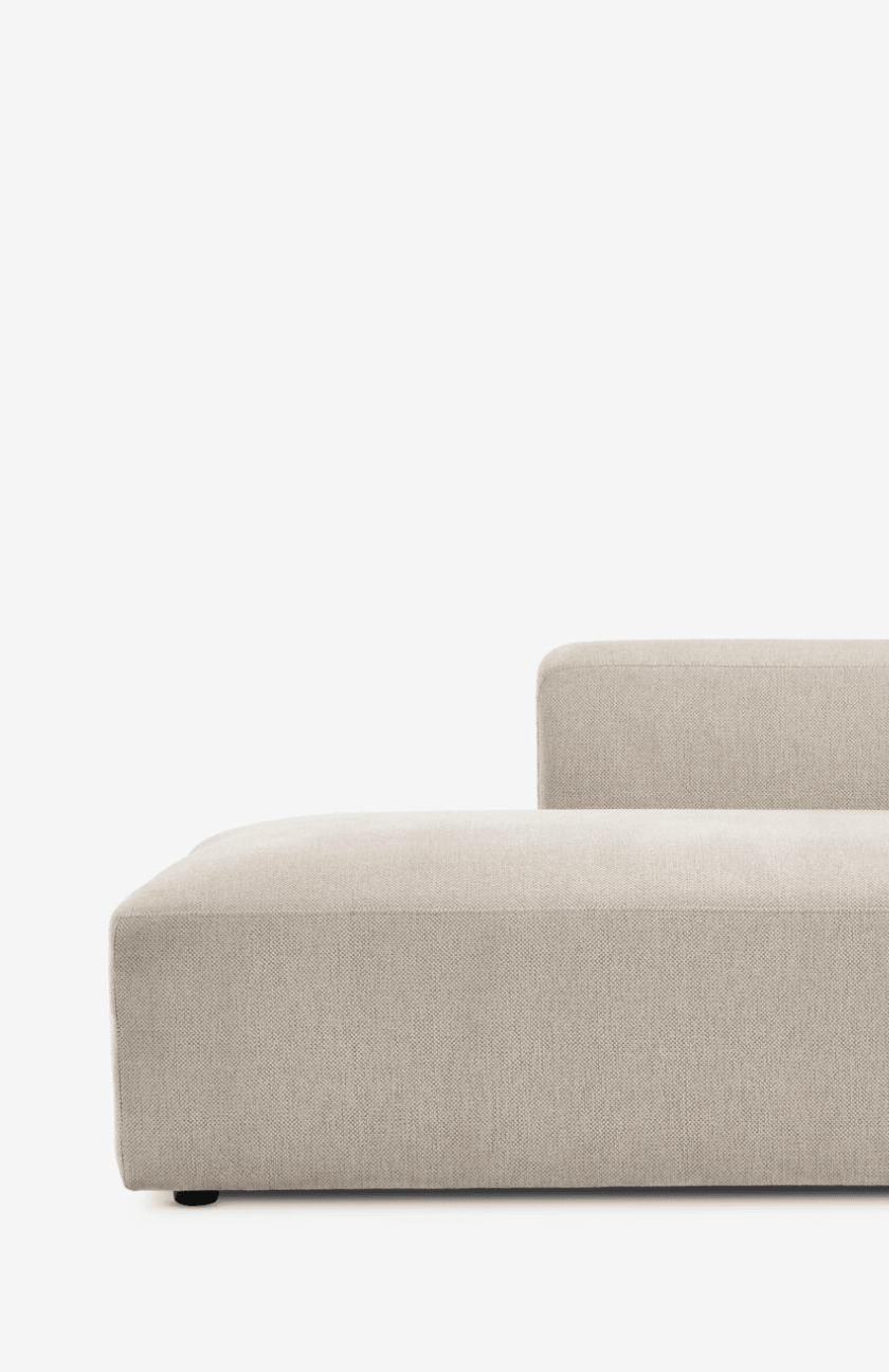 Modular sofas Close-up of a beige modular sofa corner section with a low profile and clean tailored seams, against a plain white background.