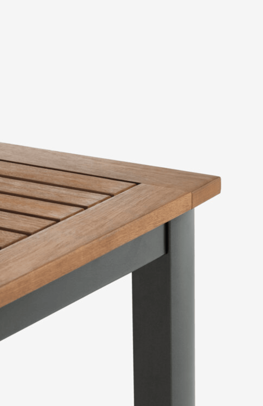Wooden tables Close-up corner of a teak slatted table top on a dark metal frame, shown against a plain white background.