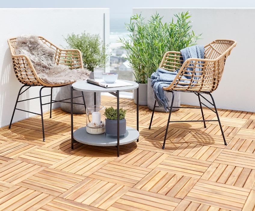 Lounge chairs and a lounge table on a patio with wooden deck tiles 