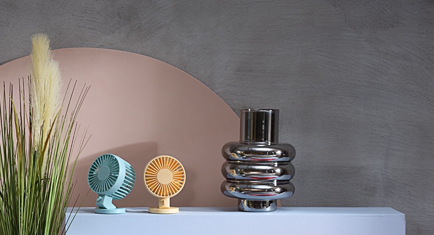 Two NIELSEN mini fans and MAGNIS metal vase beside GODSKE artificial plant Two mini fans and metal vase beside an artificial plant