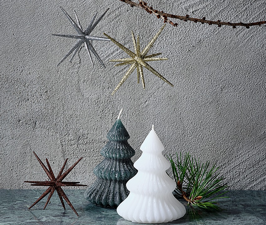 Two candles shaped like Christmas trees and Christmas stars in gold, silver and brown.