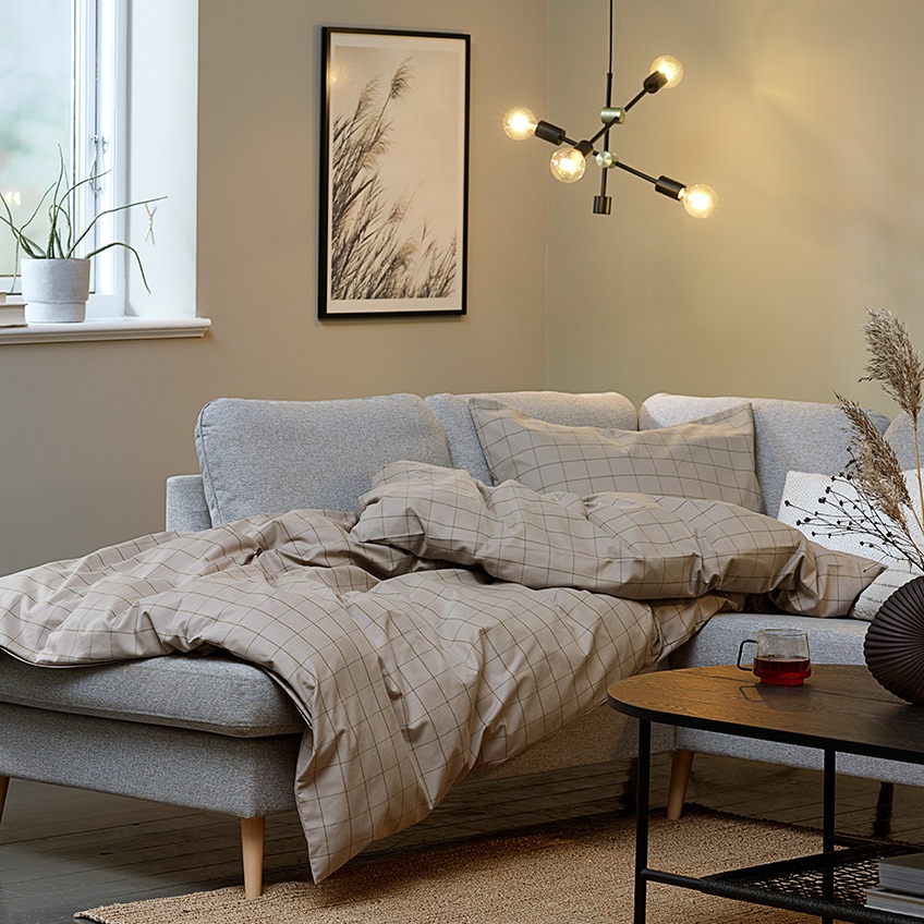 Living room “hygge” with big corner sofa, duvet and lighting 