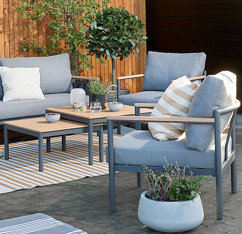 ODDESUND lounge set with a sofa, two chairs and two tables Garden lounge set with comfy cushions on a patio with rugs and planters