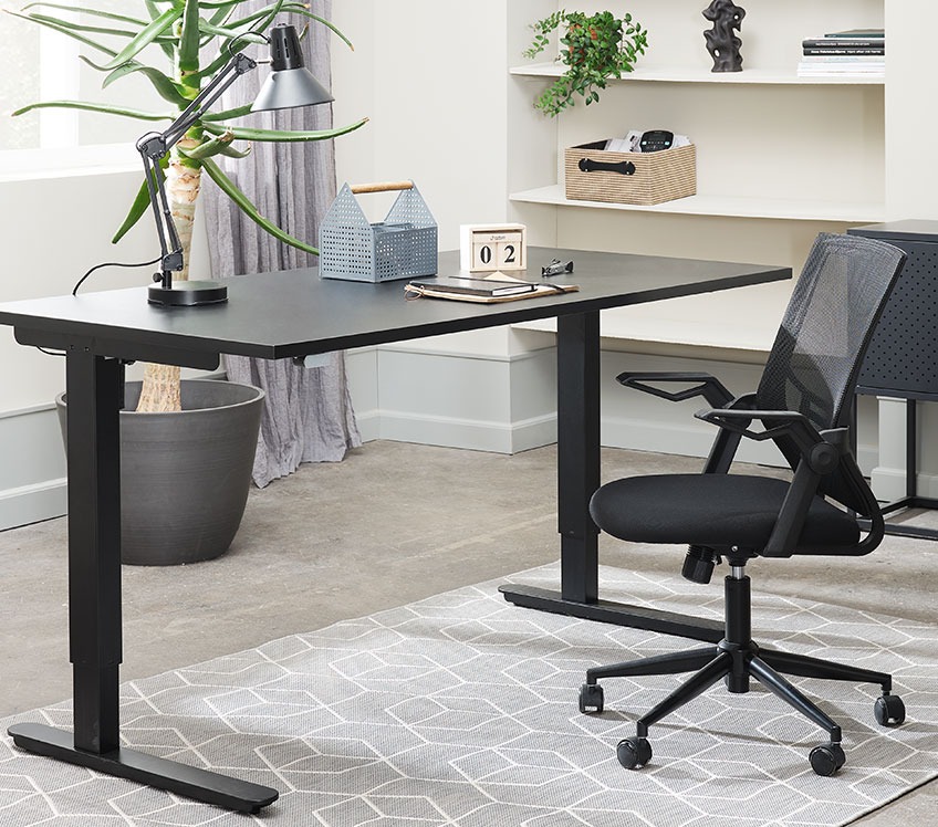 Mesh office chair at a black adjustable desk 