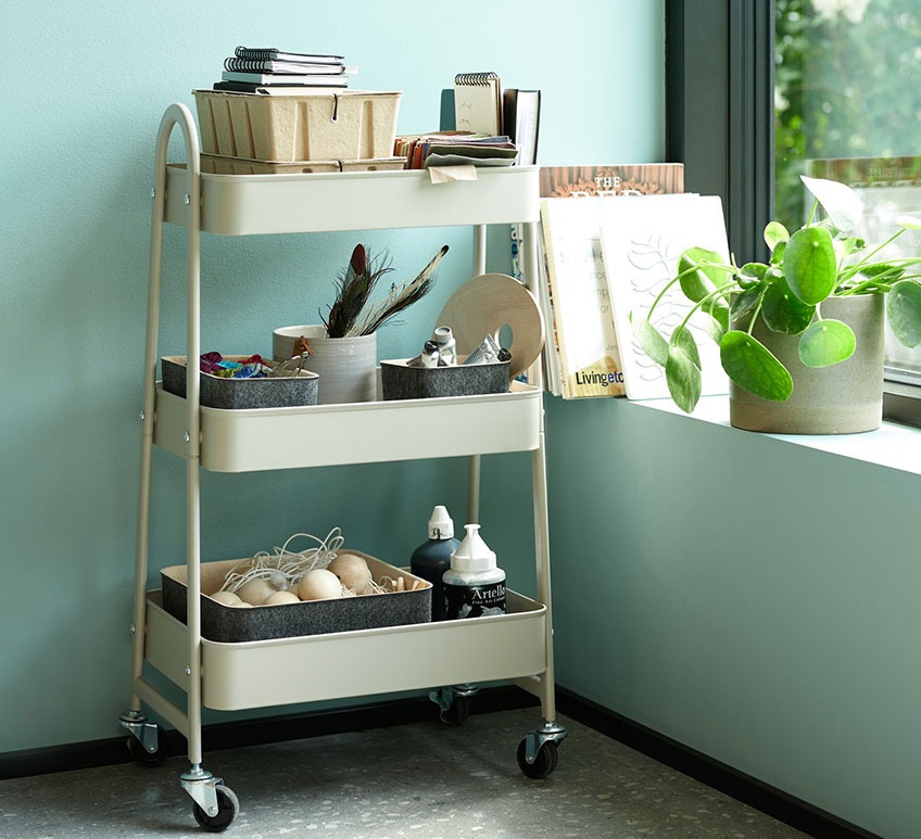 Sand coloured trolley with storage boxes and felt baskets by a window 