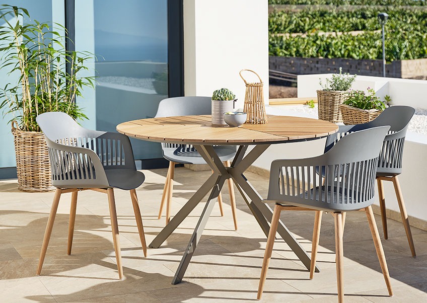Okrúhly záhradný stôl so sivými záhradnými stoličkami 