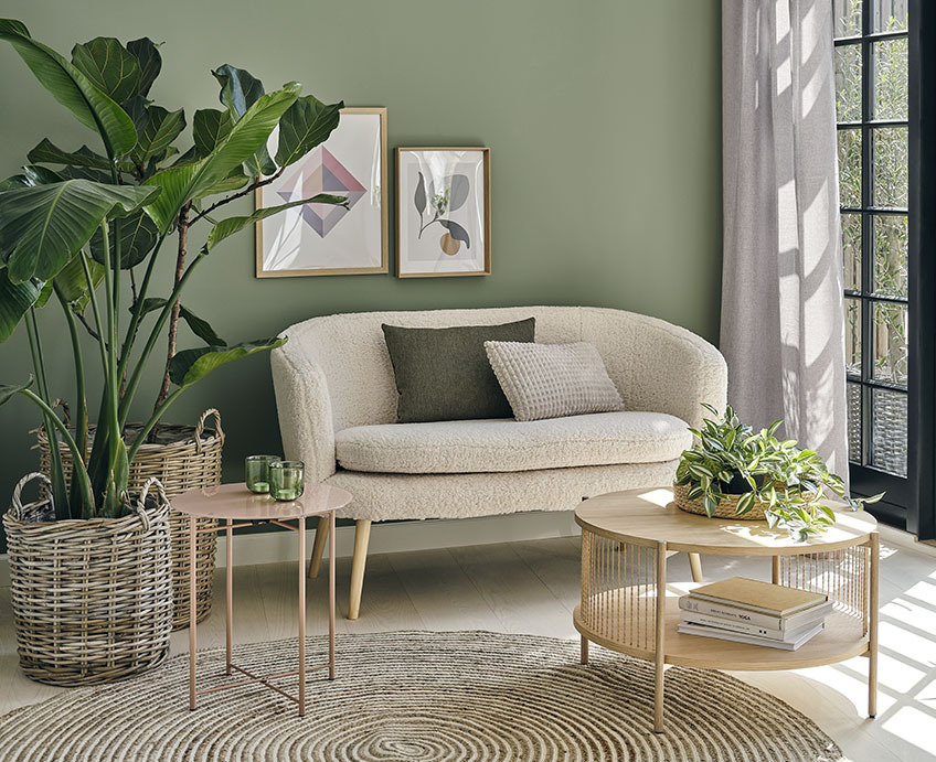 Obývacia izba s bielou pohovkou, dubovým konferenčným stolíkom, a zelenými rastlinami
