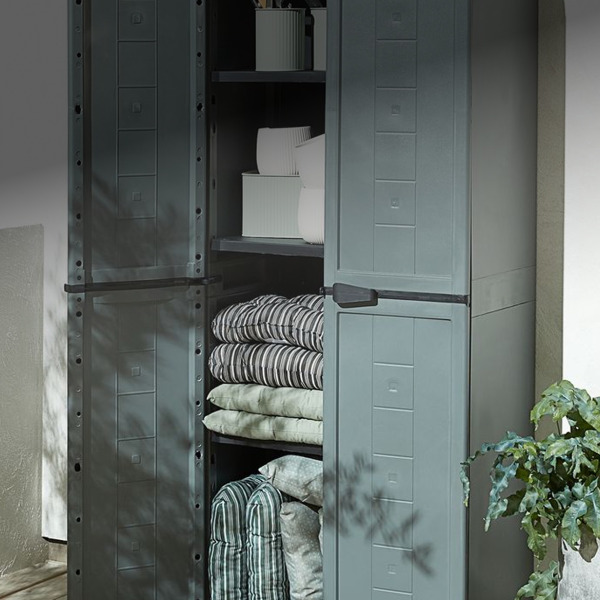 Durable storage Grey plastic outdoor storage cabinet with open doors showing shelves of tools, folded cushions, and striped seat pads, beside a potted plant.