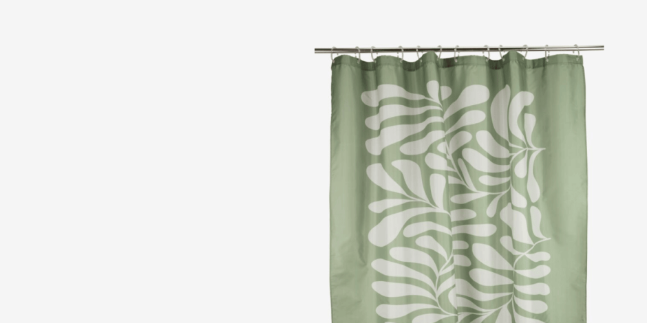 Sage green shower curtain with a white leaf pattern, hanging from a rod against a plain light background.