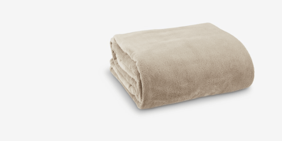 Folded beige fleece throw blanket with a soft plush texture, shown against a plain light grey background.