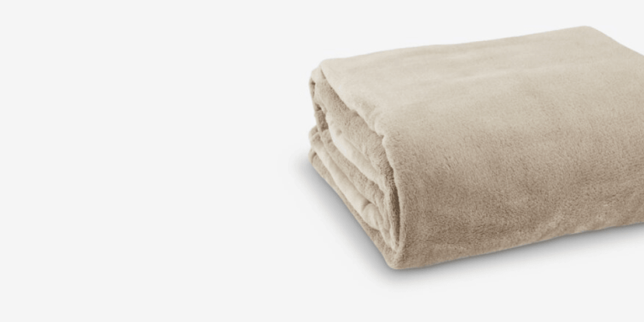 Folded beige fleece throw blanket with a soft plush texture, shown against a plain light grey background.