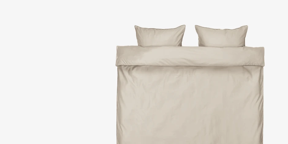 Beige duvet cover set with matching pillowcases, shown folded flat against a plain light grey background.