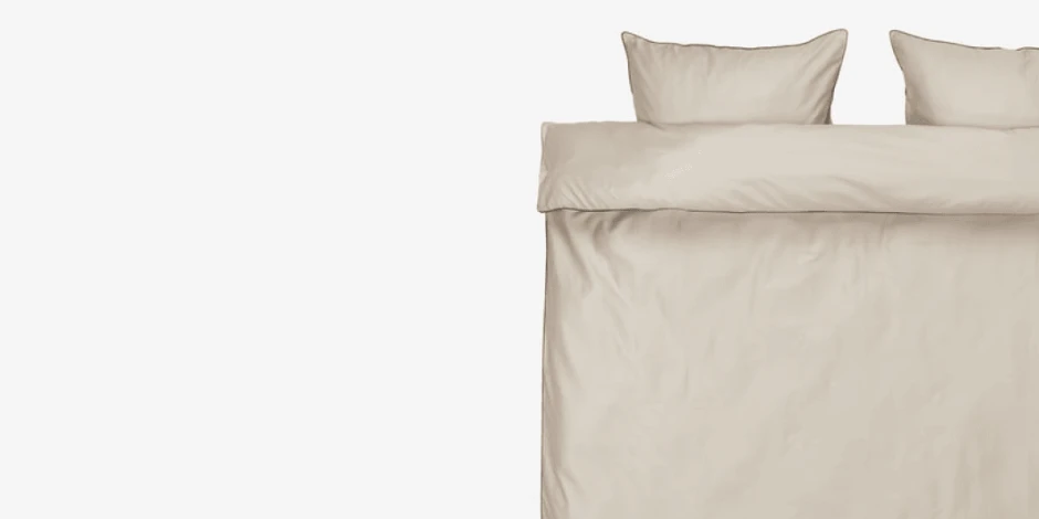 Beige duvet cover set with matching pillowcases, shown folded flat against a plain light grey background.