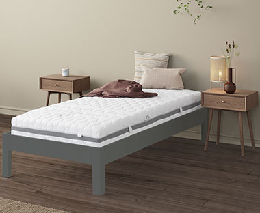 Biely matrac na sivom kovovom posteľovom ráme