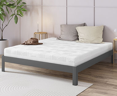 Biely matrac na sivom kovovom posteľovom ráme